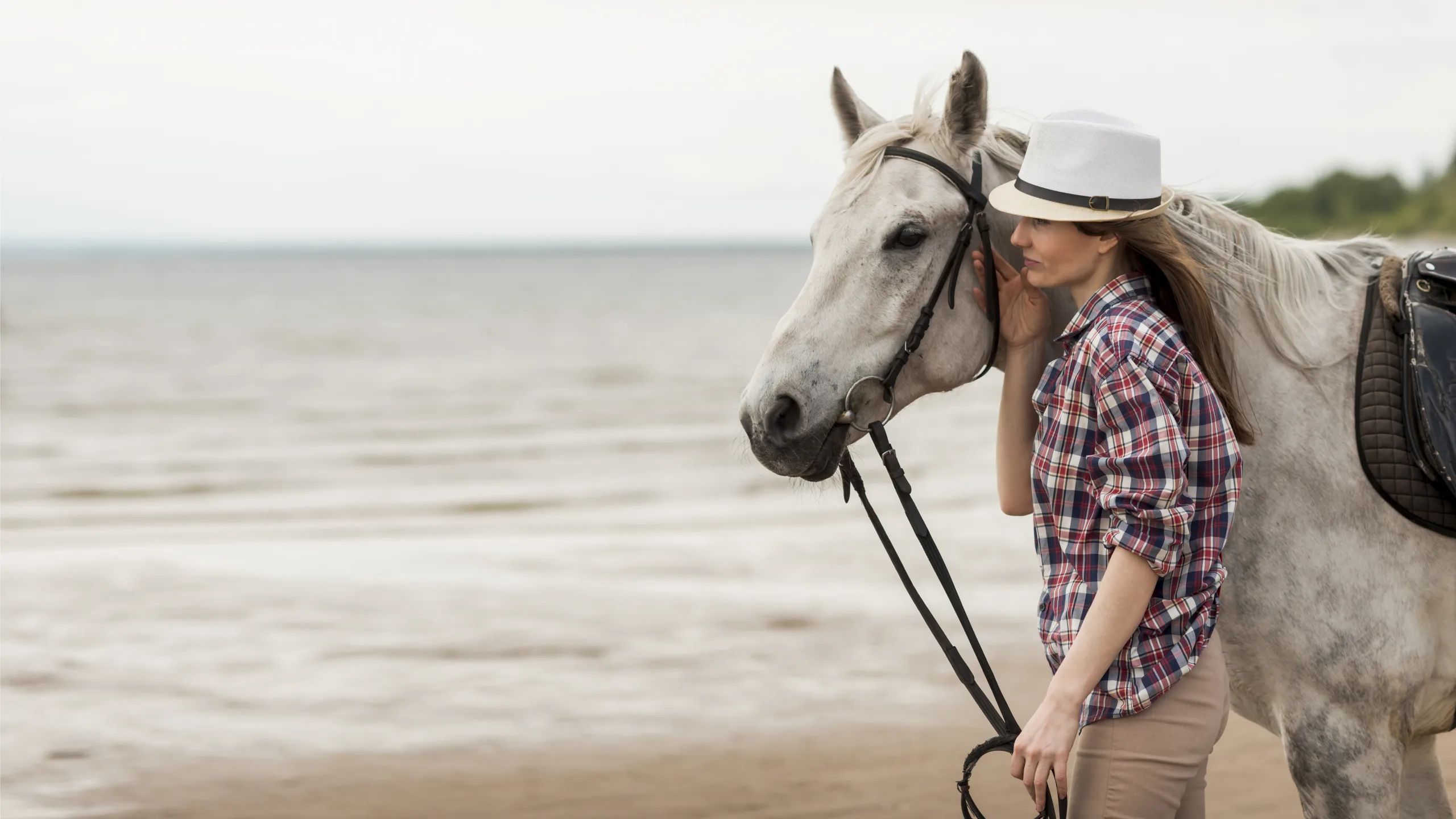 woman-walking-with-horse-beach